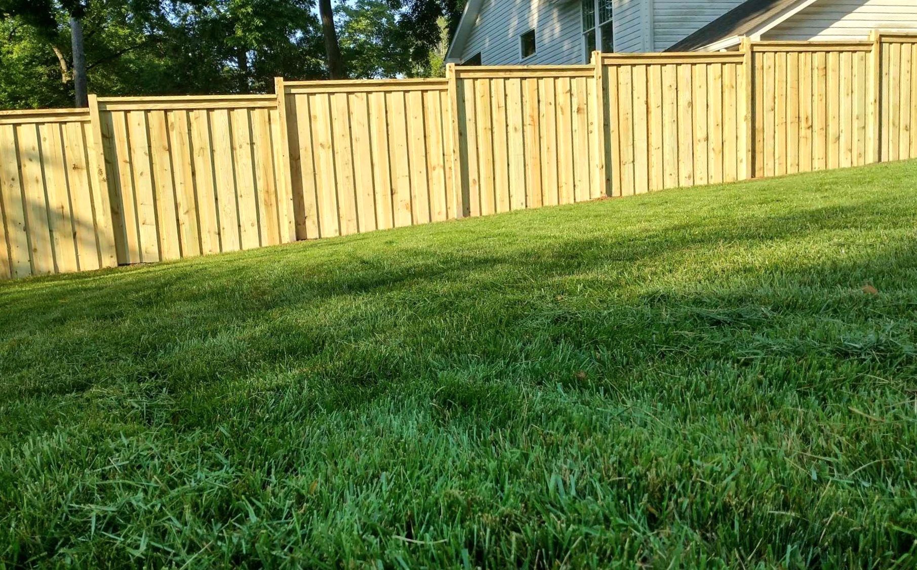 Six-foot wood stockade privacy fence with dog-ear pickets.