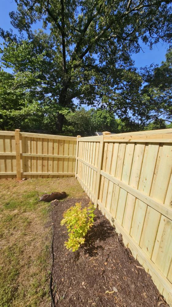 Solid wood stockade fence with capped posts.