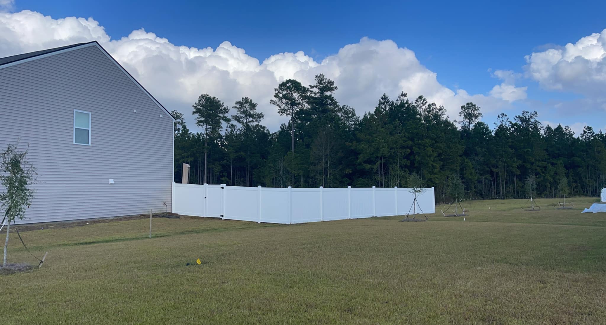 White vinyl privacy fence section with a matching gate.